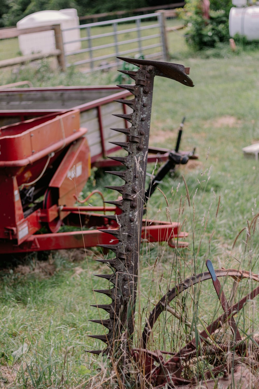 a red tractor with a large metal rake attached to it