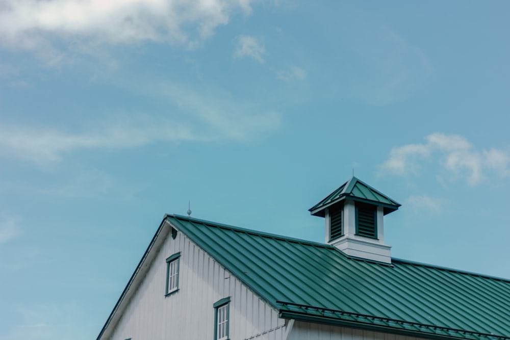 a white building with a green roof and a steeple