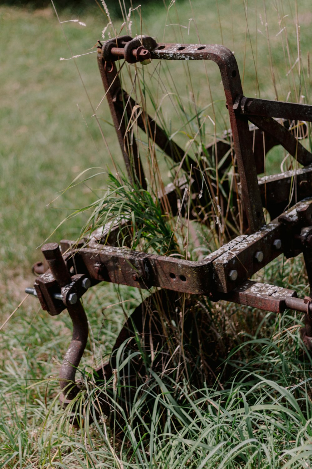 a rusted metal bench sitting in the grass