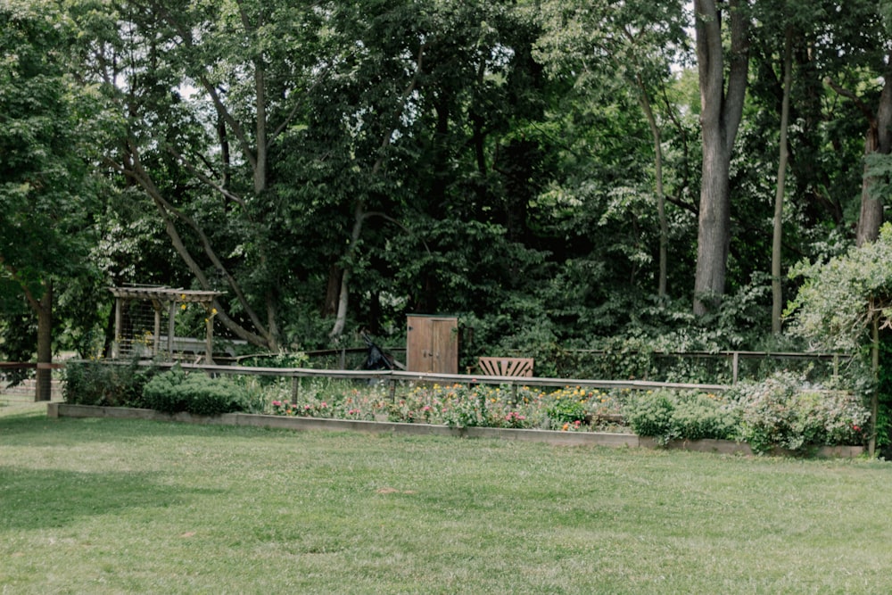 a wooden bench sitting in the middle of a lush green park