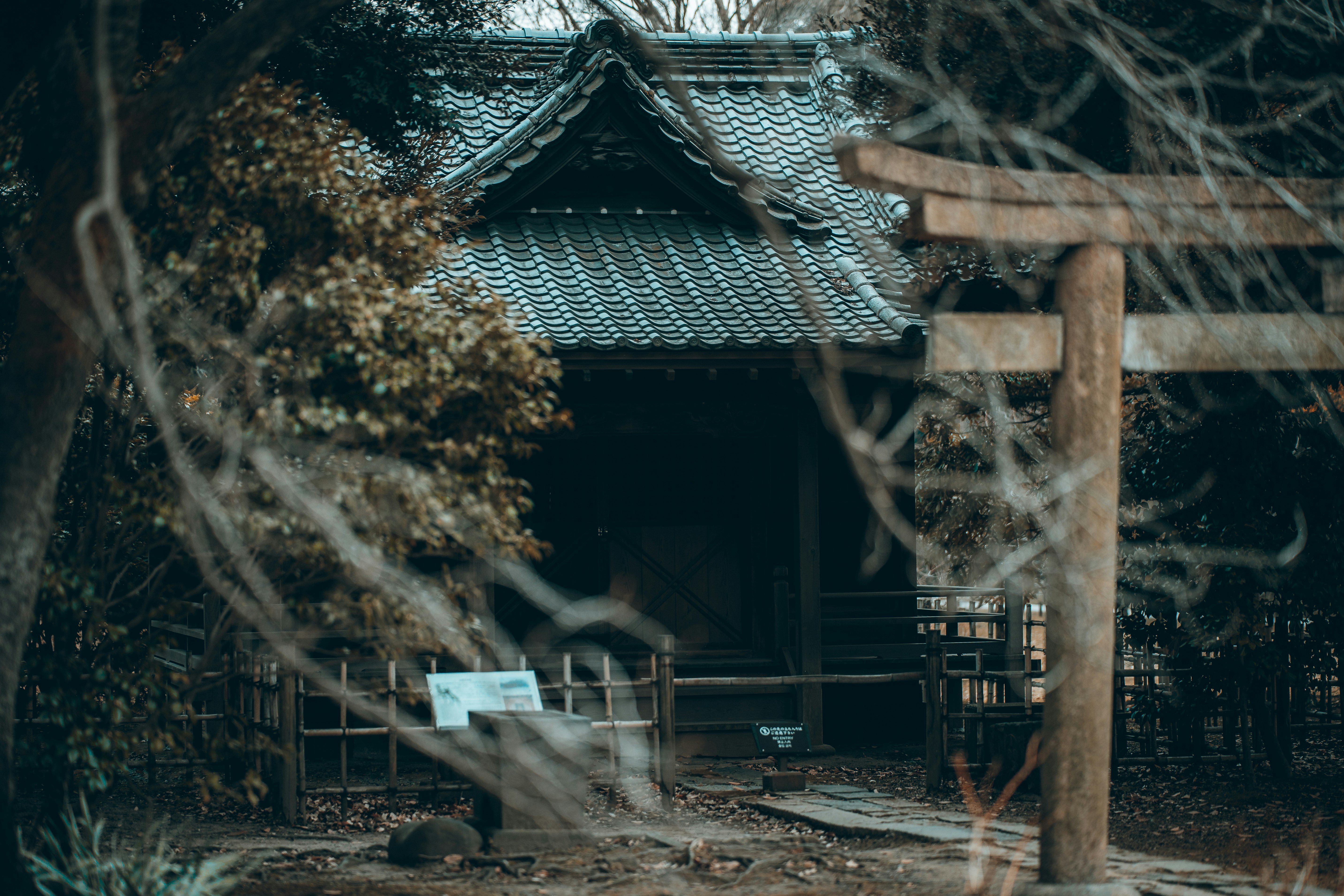 a small building with a wooden gate in front of it, 
