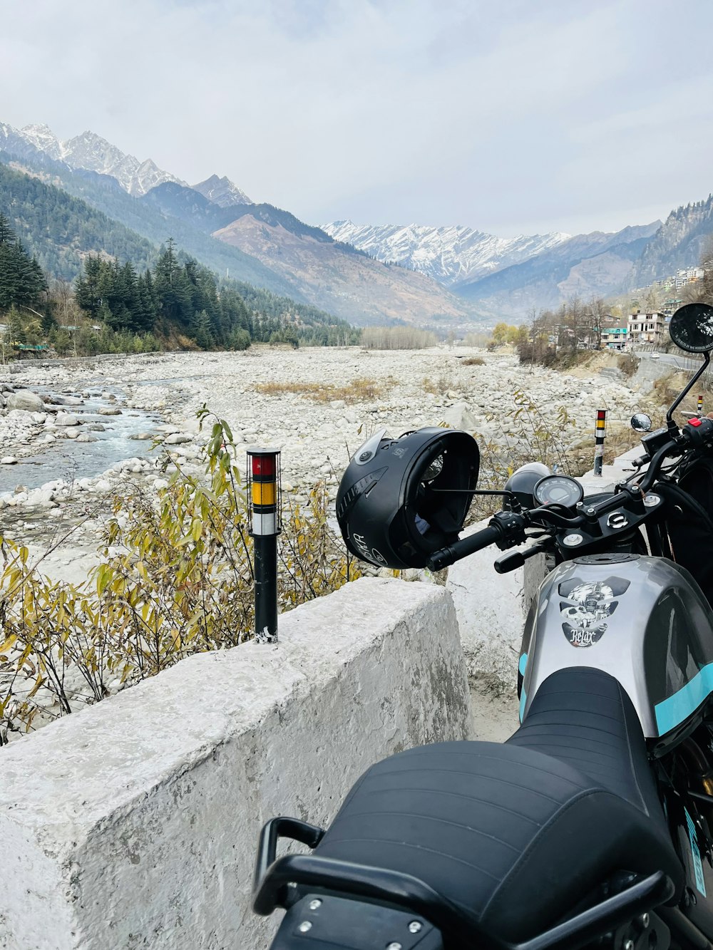 a motorcycle parked on the side of a road next to a river