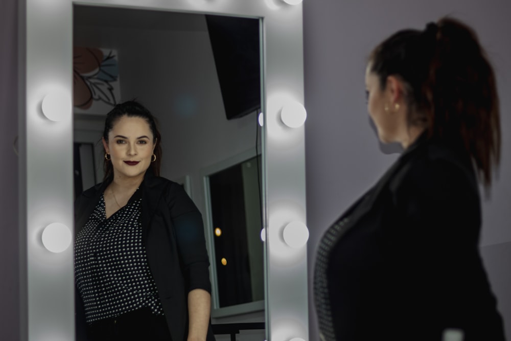 a woman standing in front of a mirror