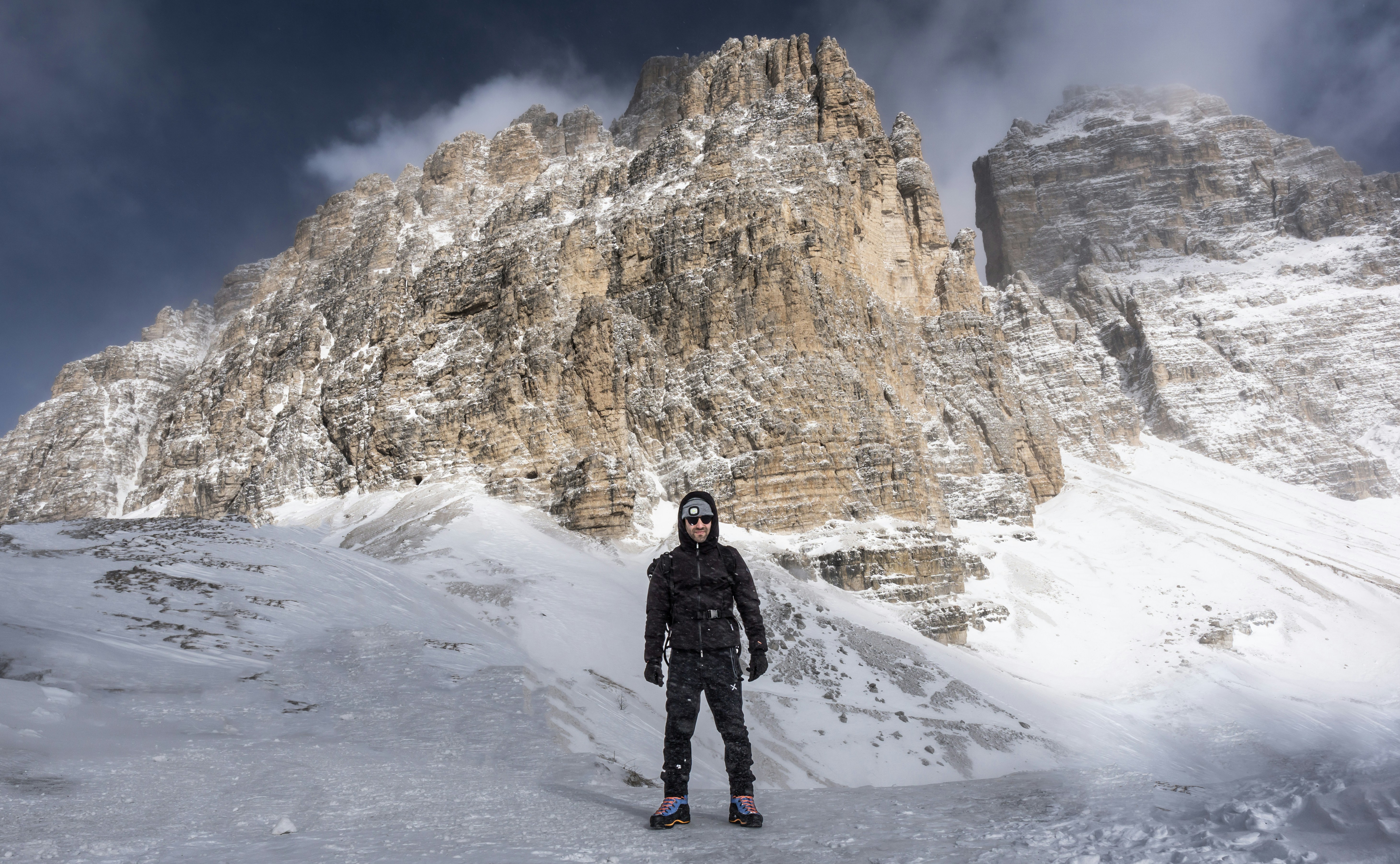 Fotomural a man standing on top of a snow covered slope