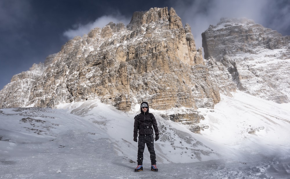 a man standing on top of a snow covered slope