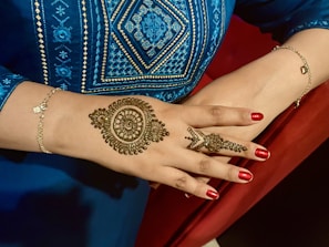 a woman's hand with henna tattoos on it