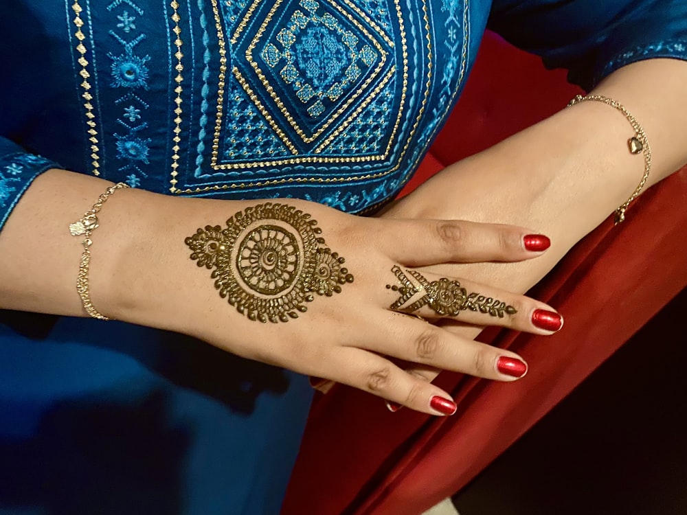 a mão de uma mulher com tatuagens de henna sobre ele