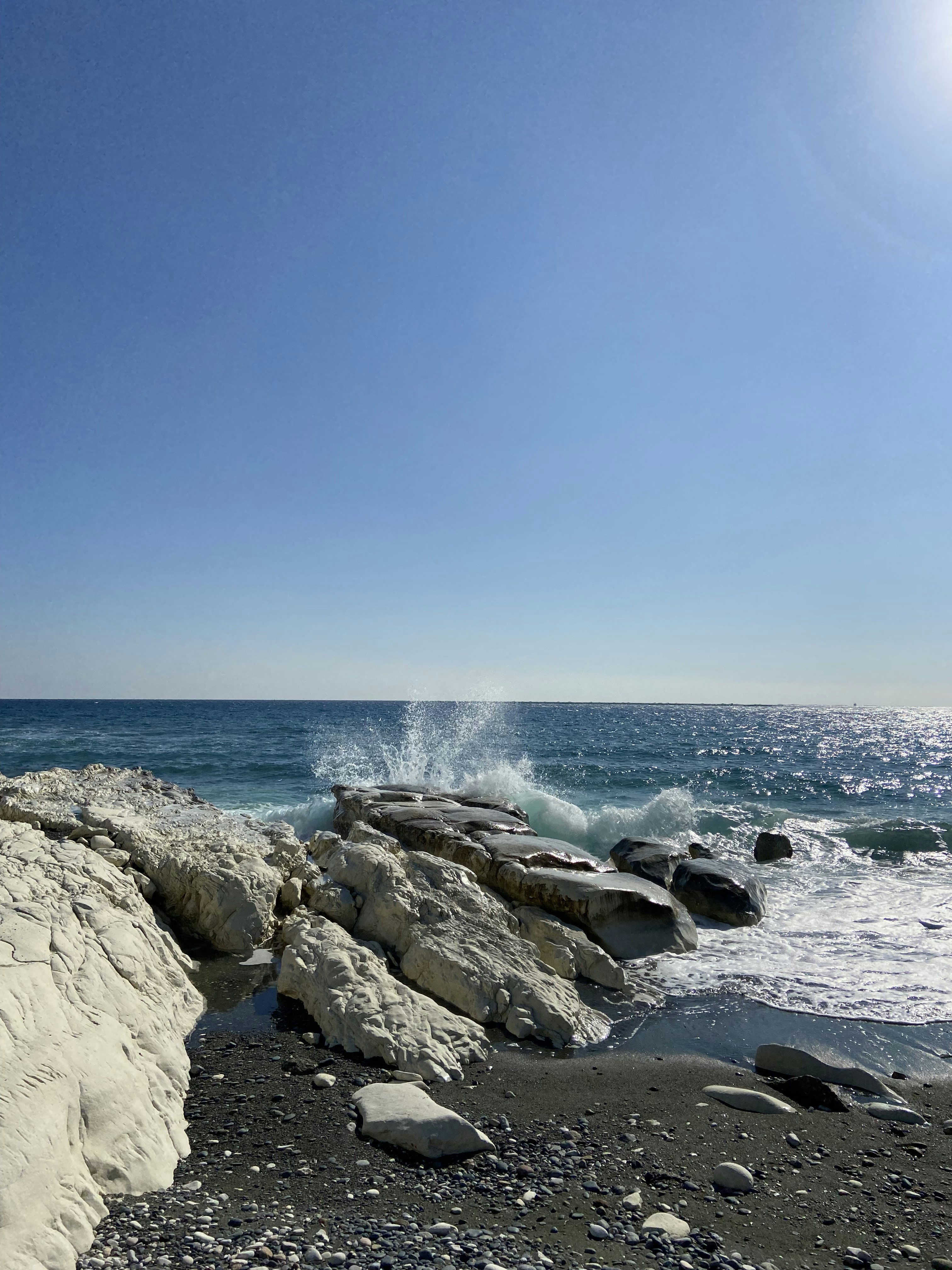 a person standing on a rocky beach next to the ocean