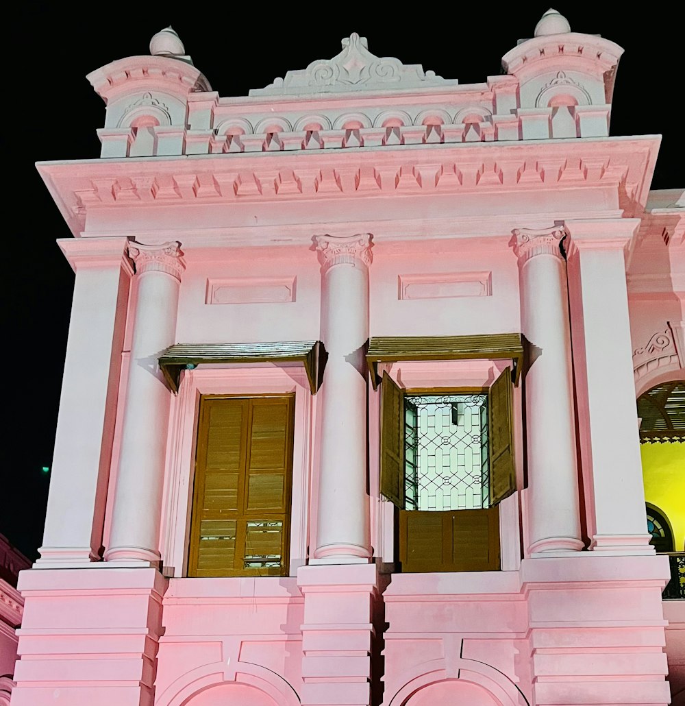 a pink building with two doors and a window
