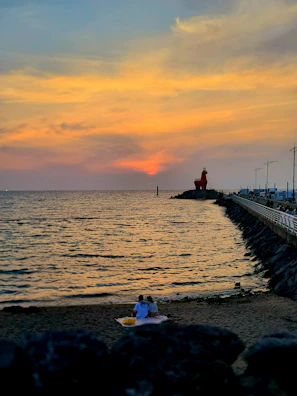A sunlit couple sharing a quiet moment in a sandy beach setting