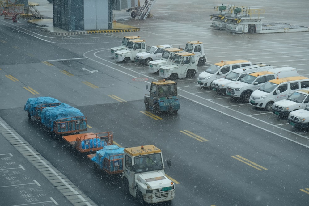 a group of trucks driving down a rain soaked street