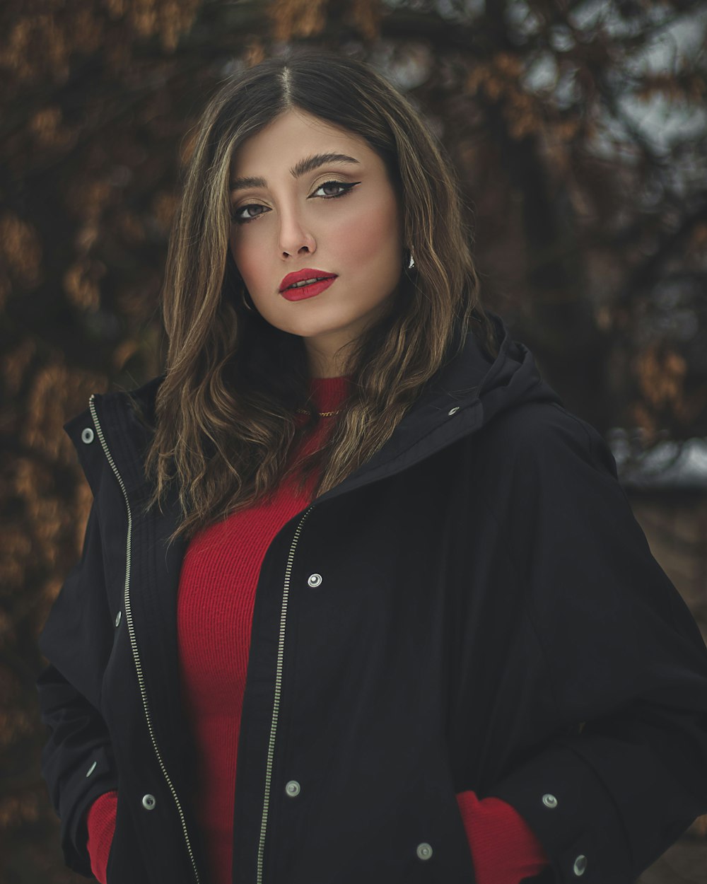 a woman in a red sweater and black jacket