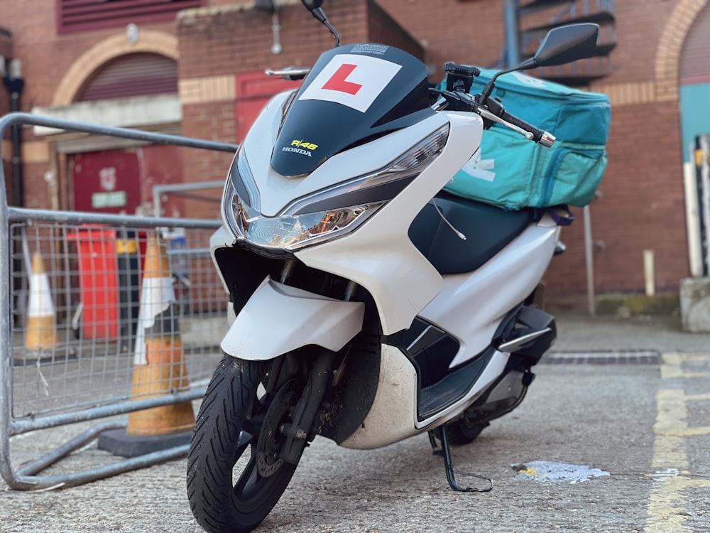 a scooter is parked in front of a fence