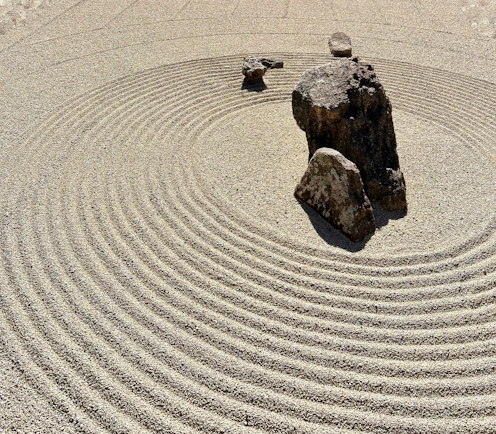 a rock sits in the middle of a circular rock garden