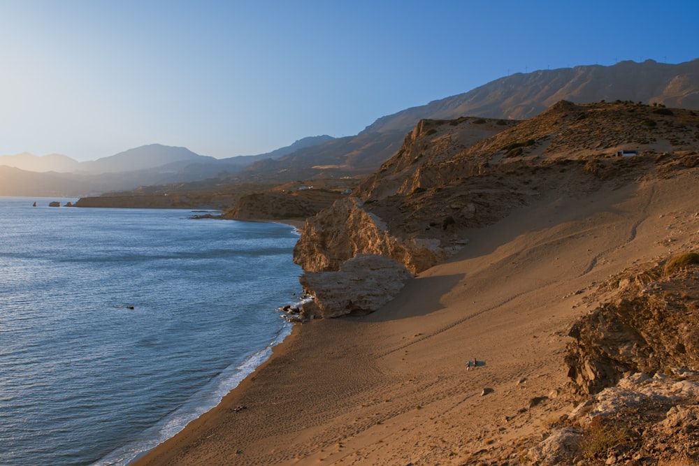 a sandy beach next to a body of water