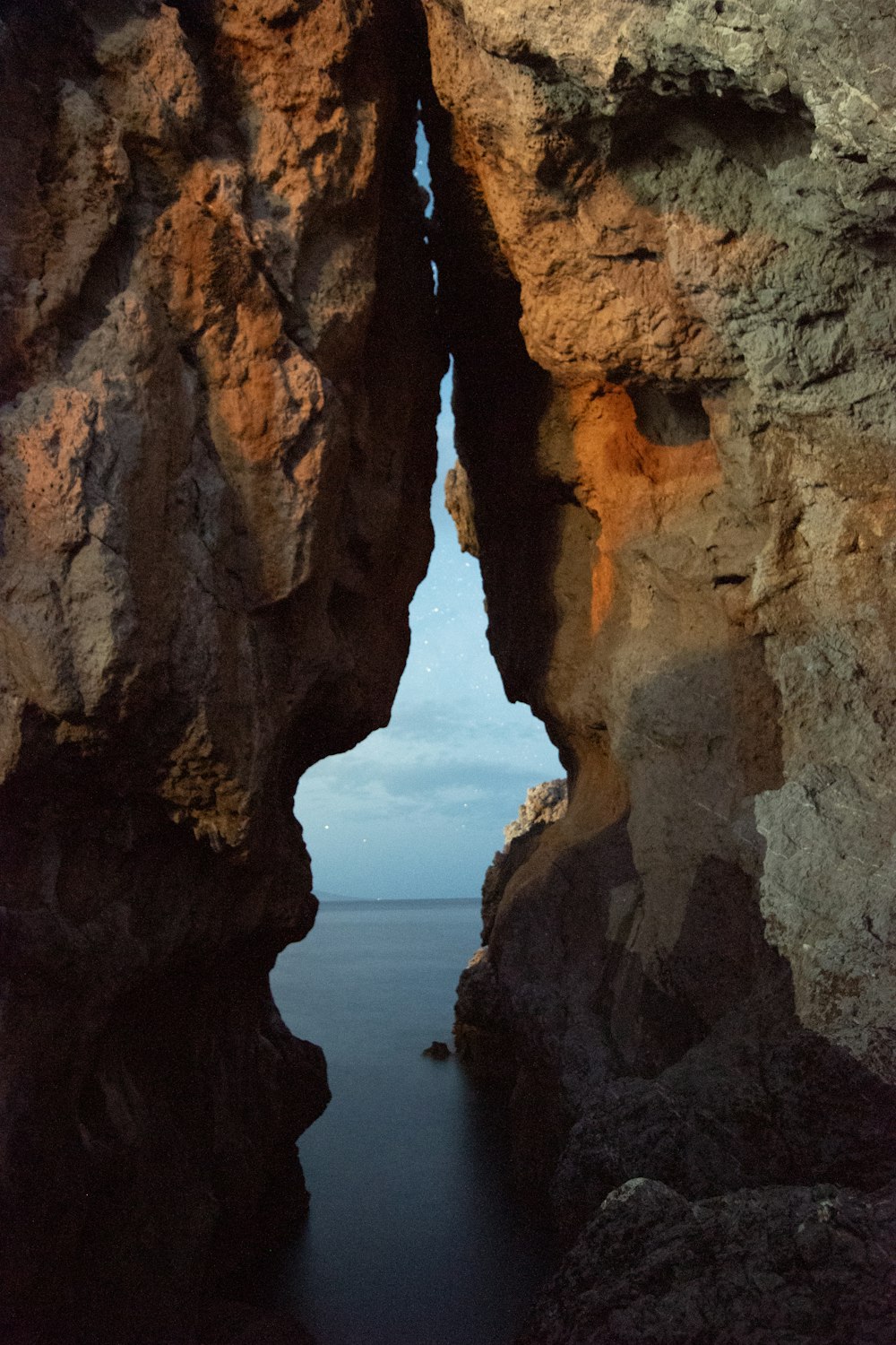 a view of a body of water through two large rocks