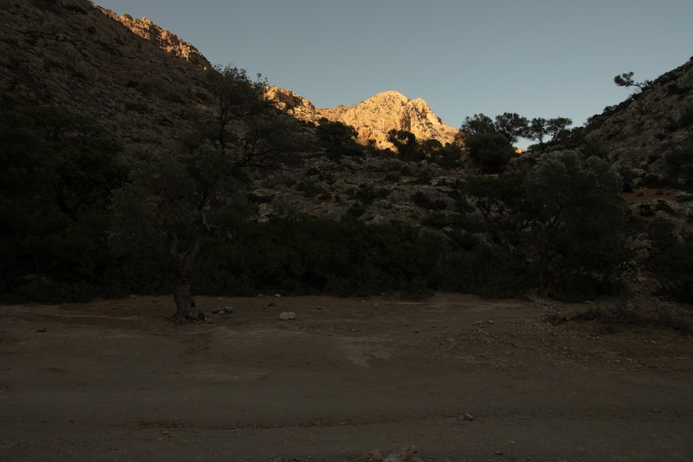 the sun is setting on a rocky mountain