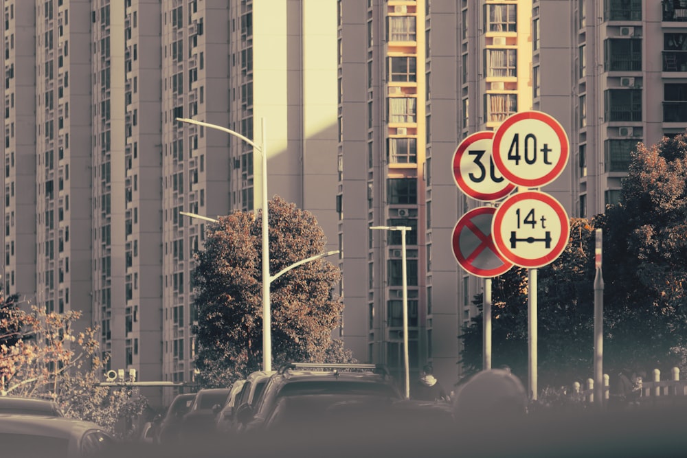 a couple of red and white street signs sitting on the side of a road