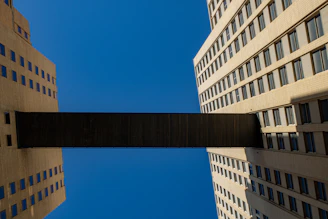 Two office buildings linked by a visible wireless signal beam under a bright blue sky.