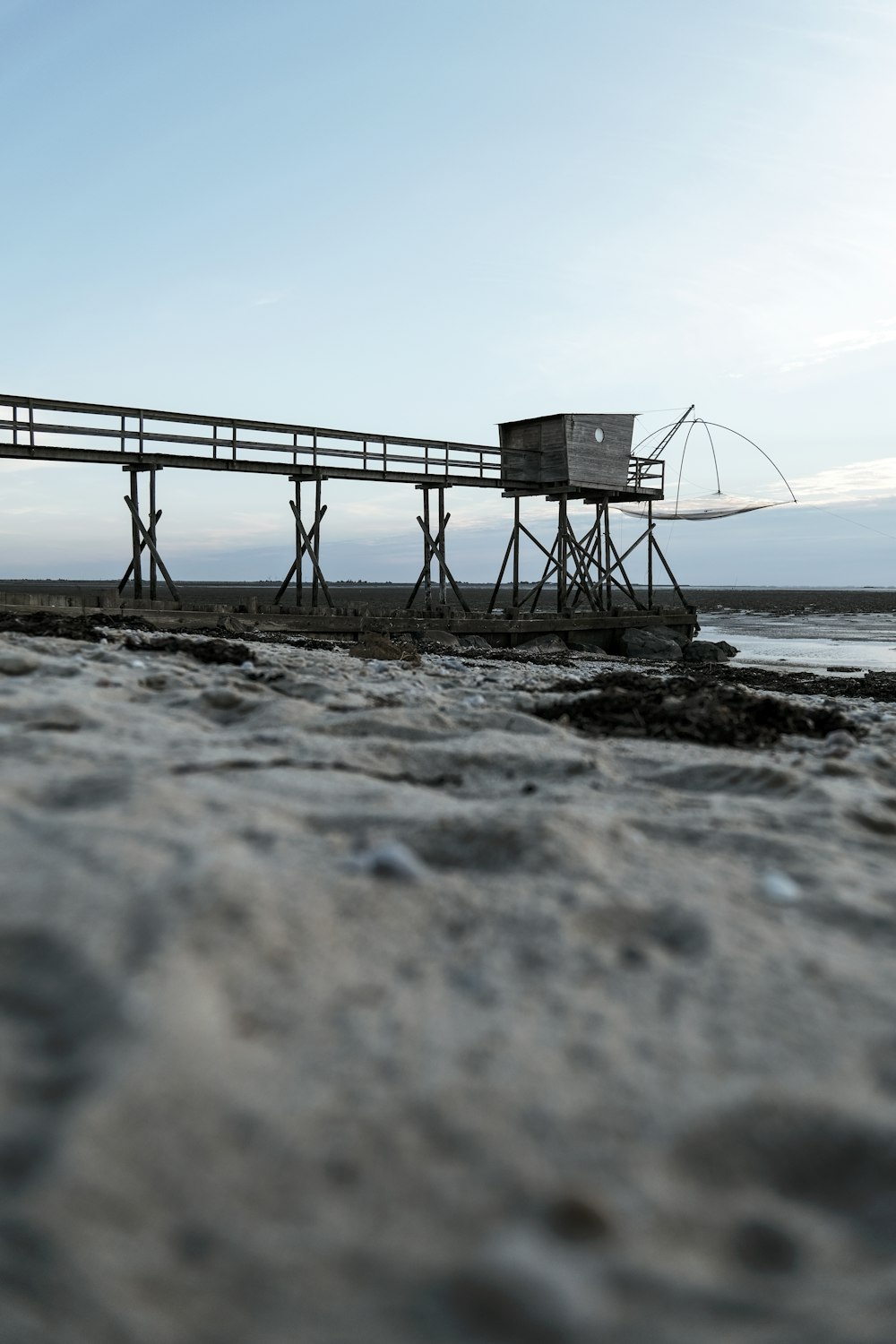 a wooden pier sitting on top of a sandy beach