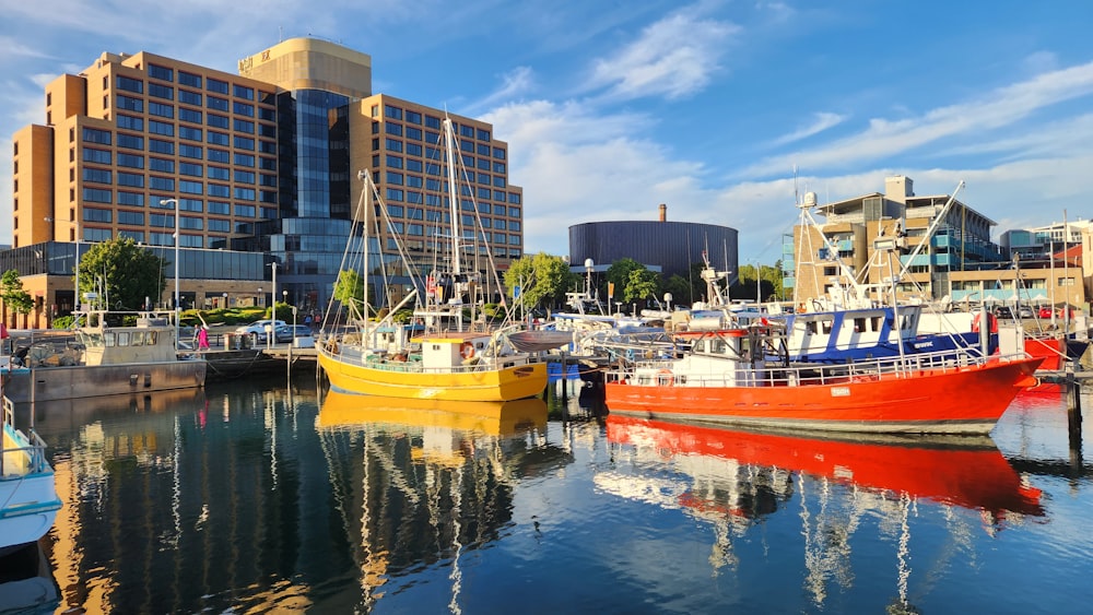 several boats are docked in a harbor in front of a large building