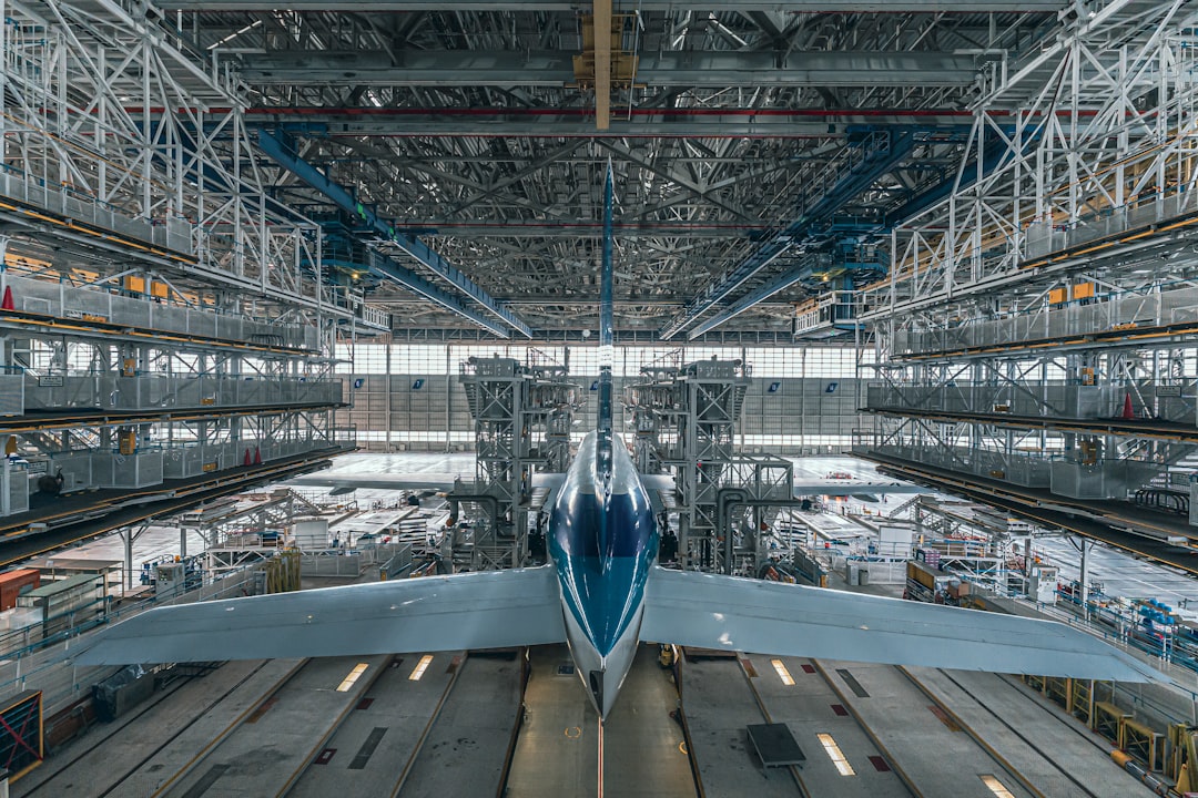 a large jetliner sitting inside of an airport hangar,