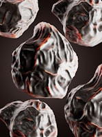 Multiple dark, textured rocks with red and white highlights are floating in a seamless pattern against a black background. The rocks have an irregular, organic shape and are depicted with detailed shading and coloring.