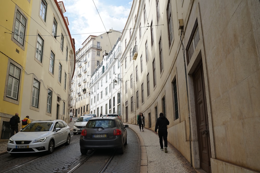 a man walking down a street next to tall buildings