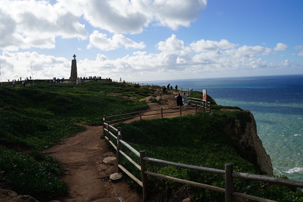 a path leading to the top of a hill next to the ocean