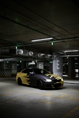 a yellow and black car parked in a parking garage