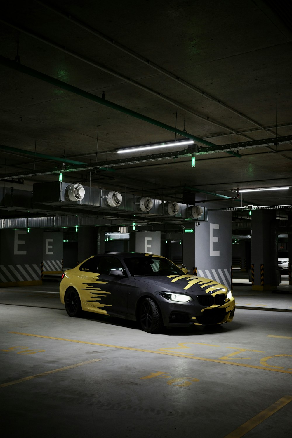 a yellow and black car parked in a parking garage