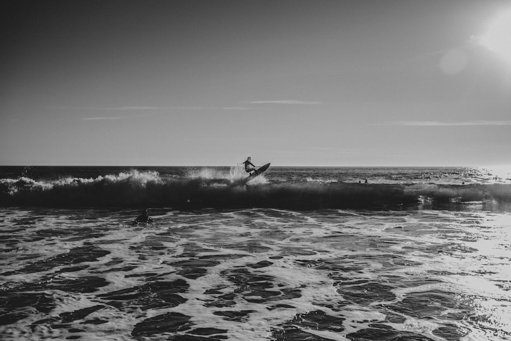 a man riding a wave on top of a surfboard