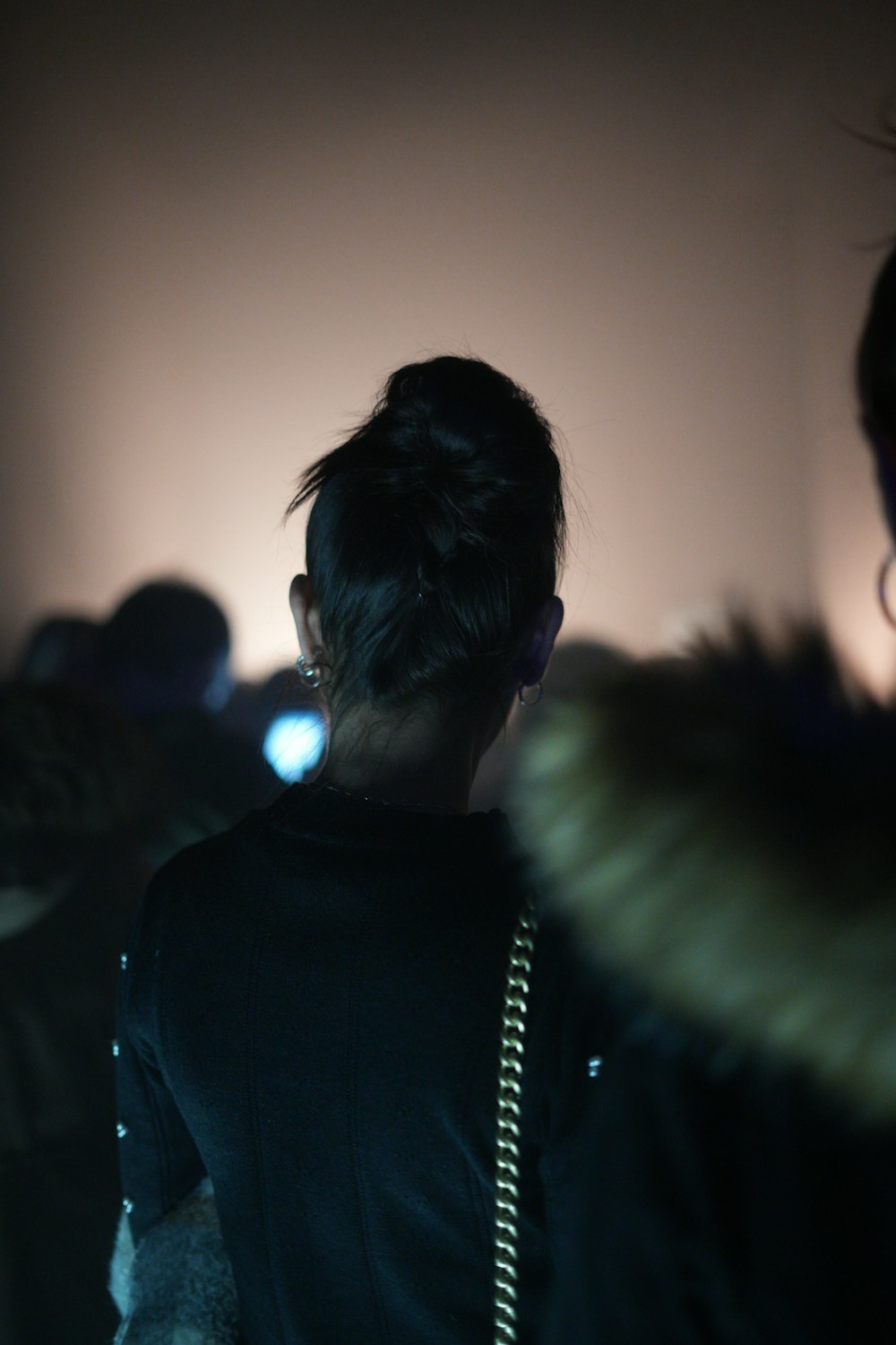 a person standing in a dark room with a cell phone