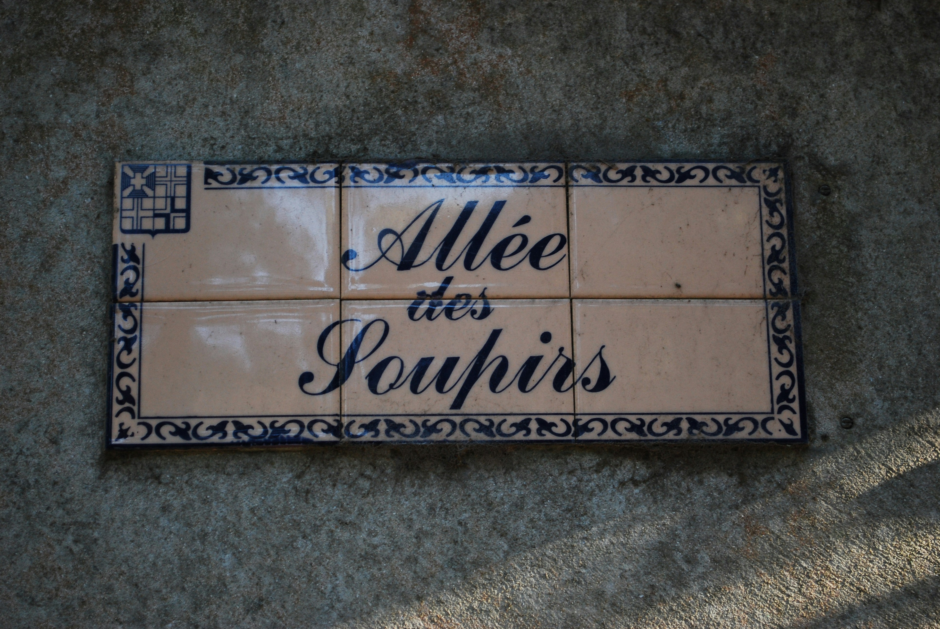 ein Fliesenschild an der Seite eines Gebäudes