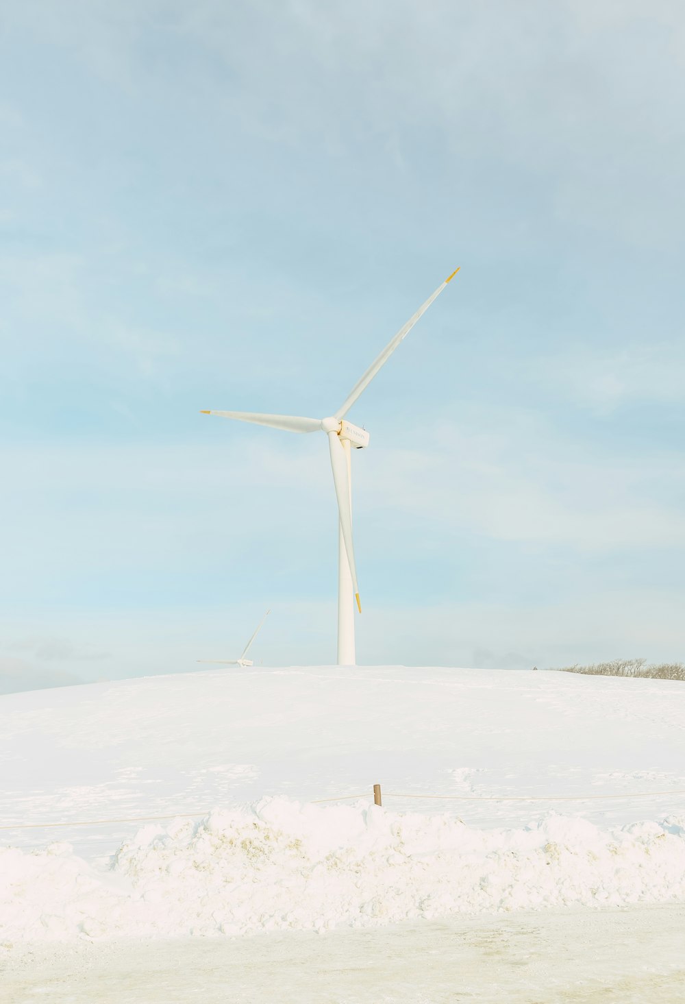 a wind turbine in the middle of a snowy field