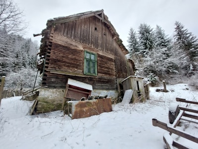Rustic mountain cabin with wooden beams and snow-covered surroundings