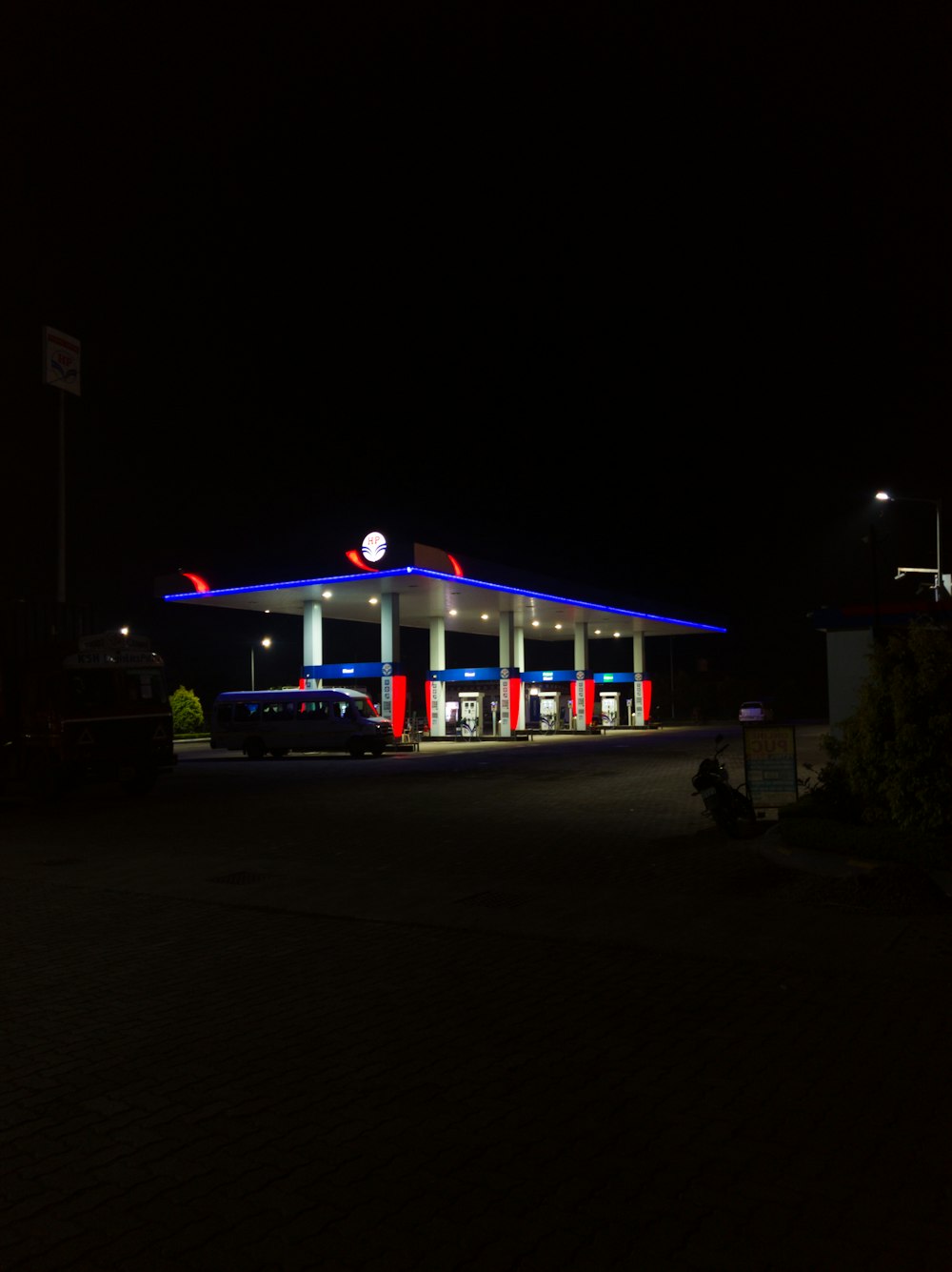 a gas station lit up at night time