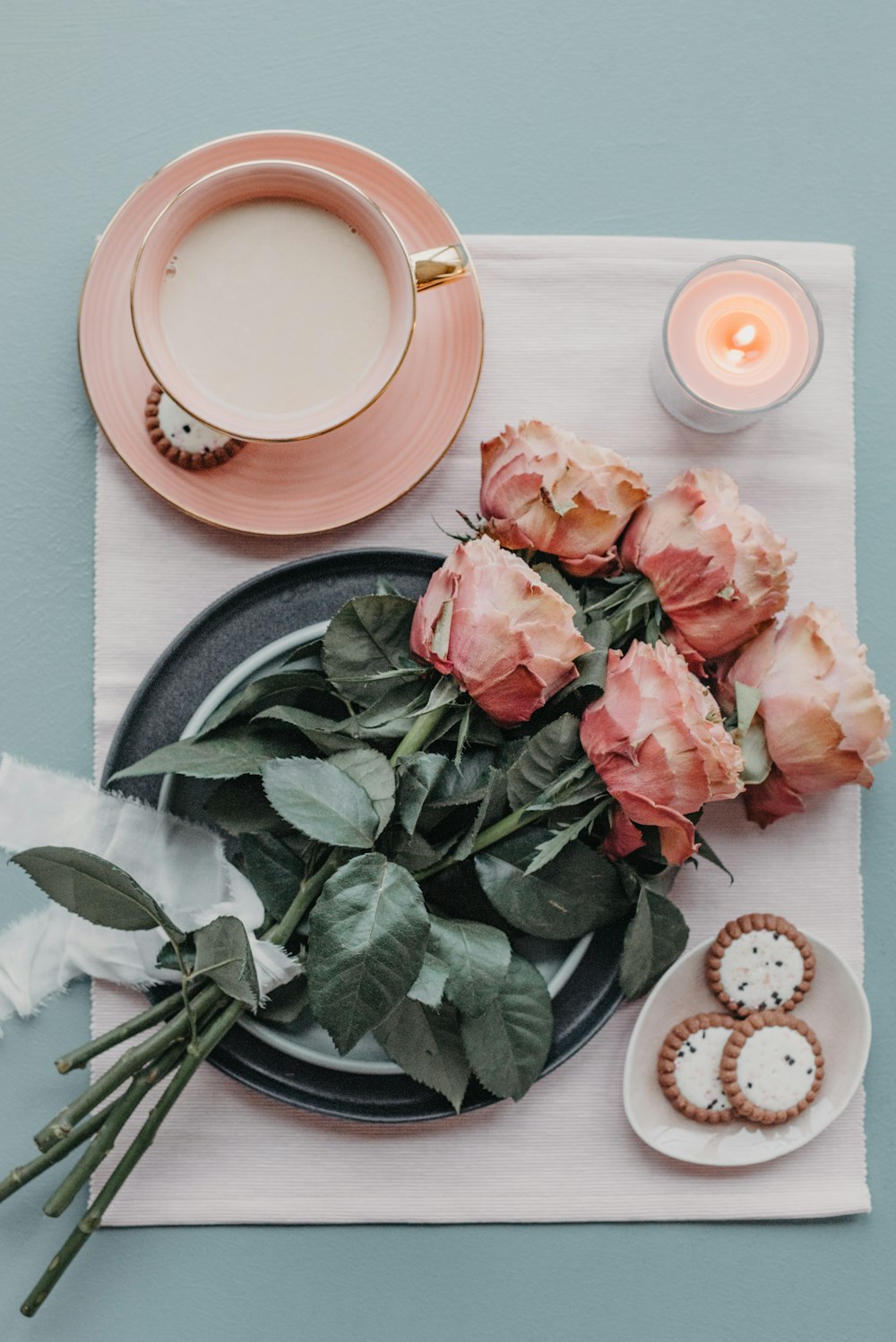 a plate with roses, cookies and a cup of coffee