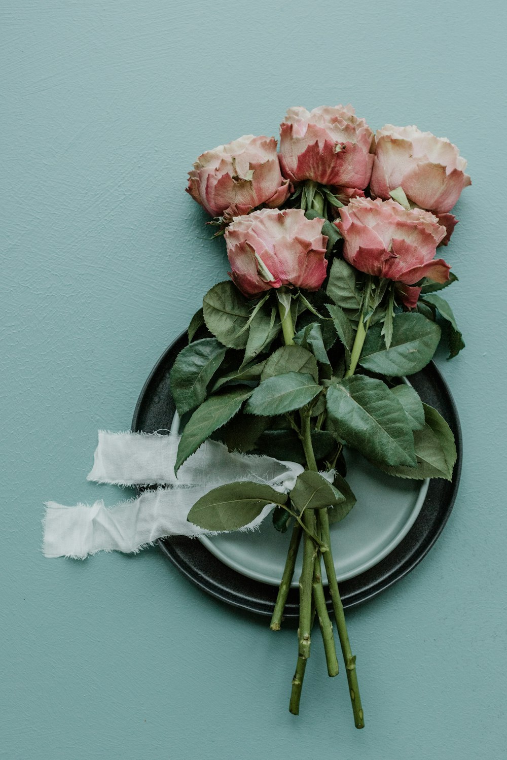 a bunch of pink roses sitting on top of a plate