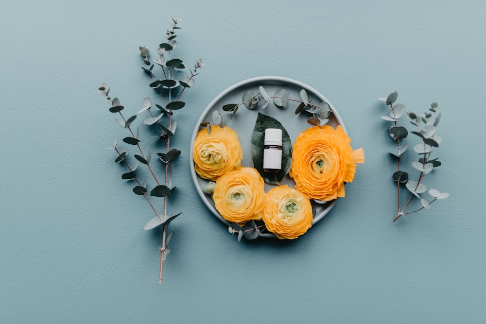 a plate with flowers and a camera on it