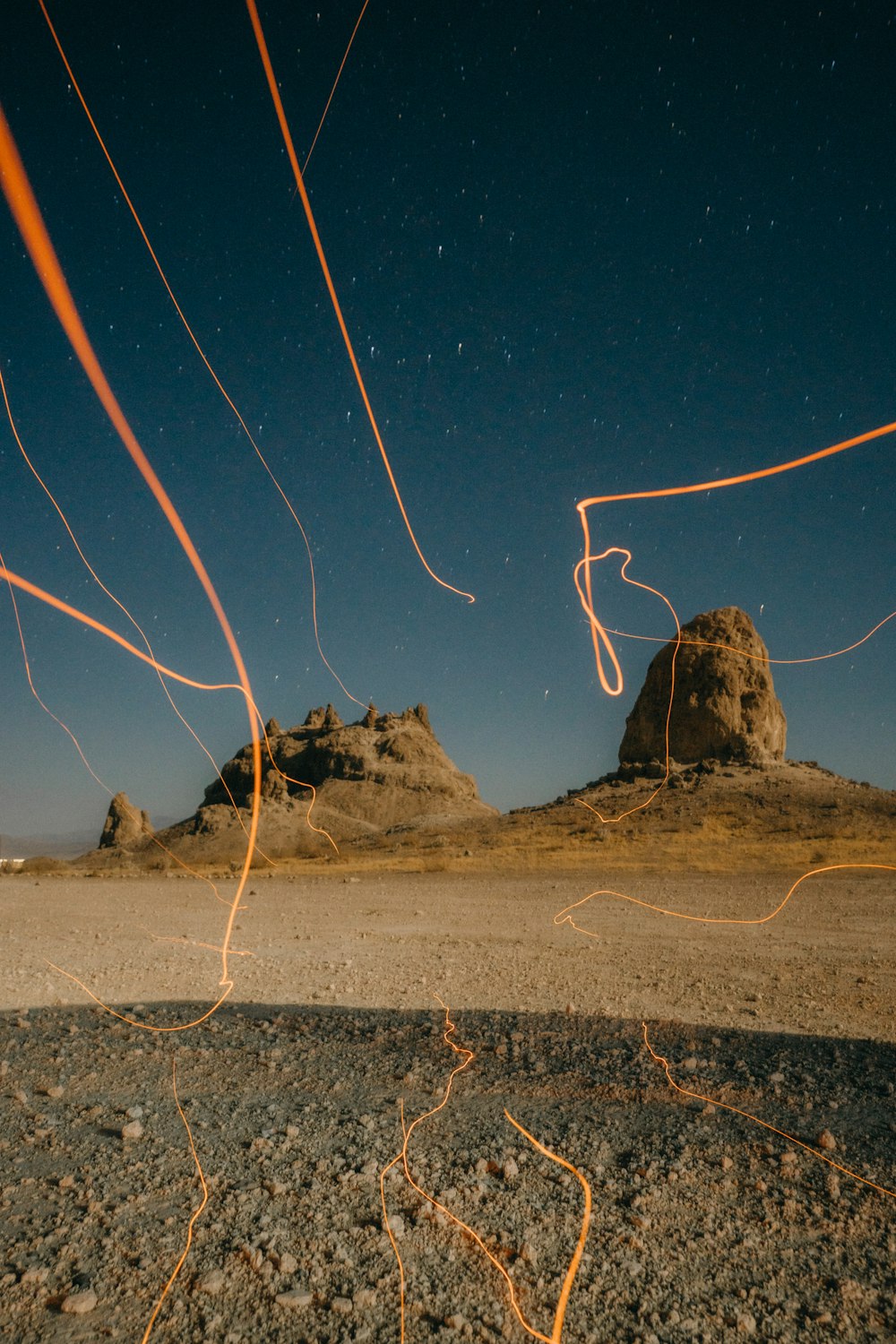 a view of a desert with a rock formation in the background