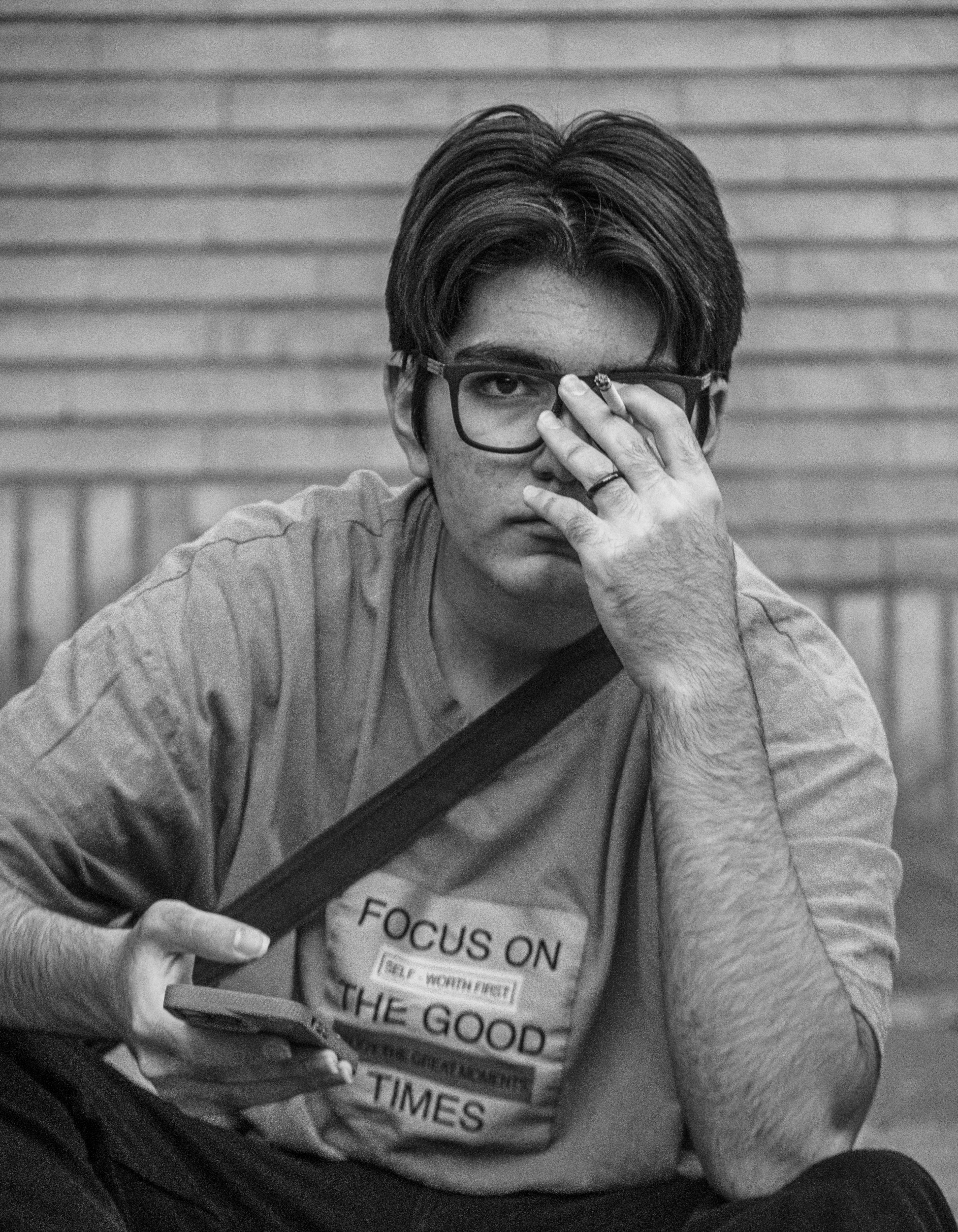 Un hombre sentado en el suelo mirando su teléfono celular