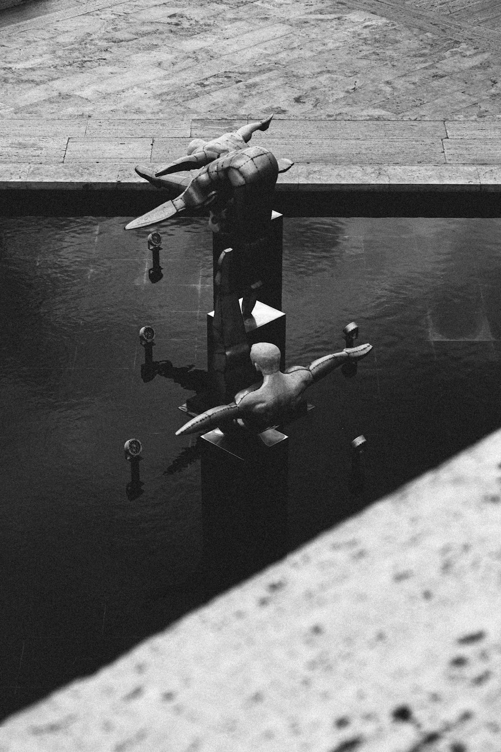 a black and white photo of a water fountain