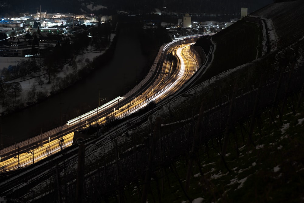 a train traveling down tracks next to a city at night