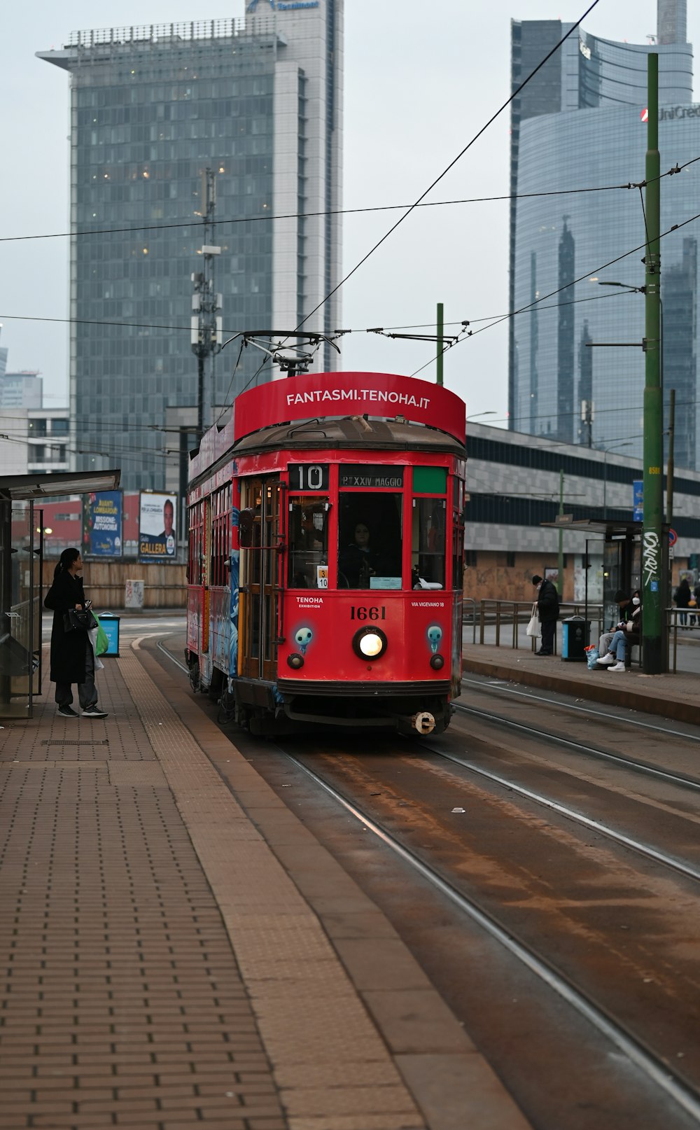 a red trolley is coming down the tracks