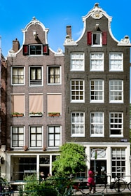 a woman walking past a tall brick building