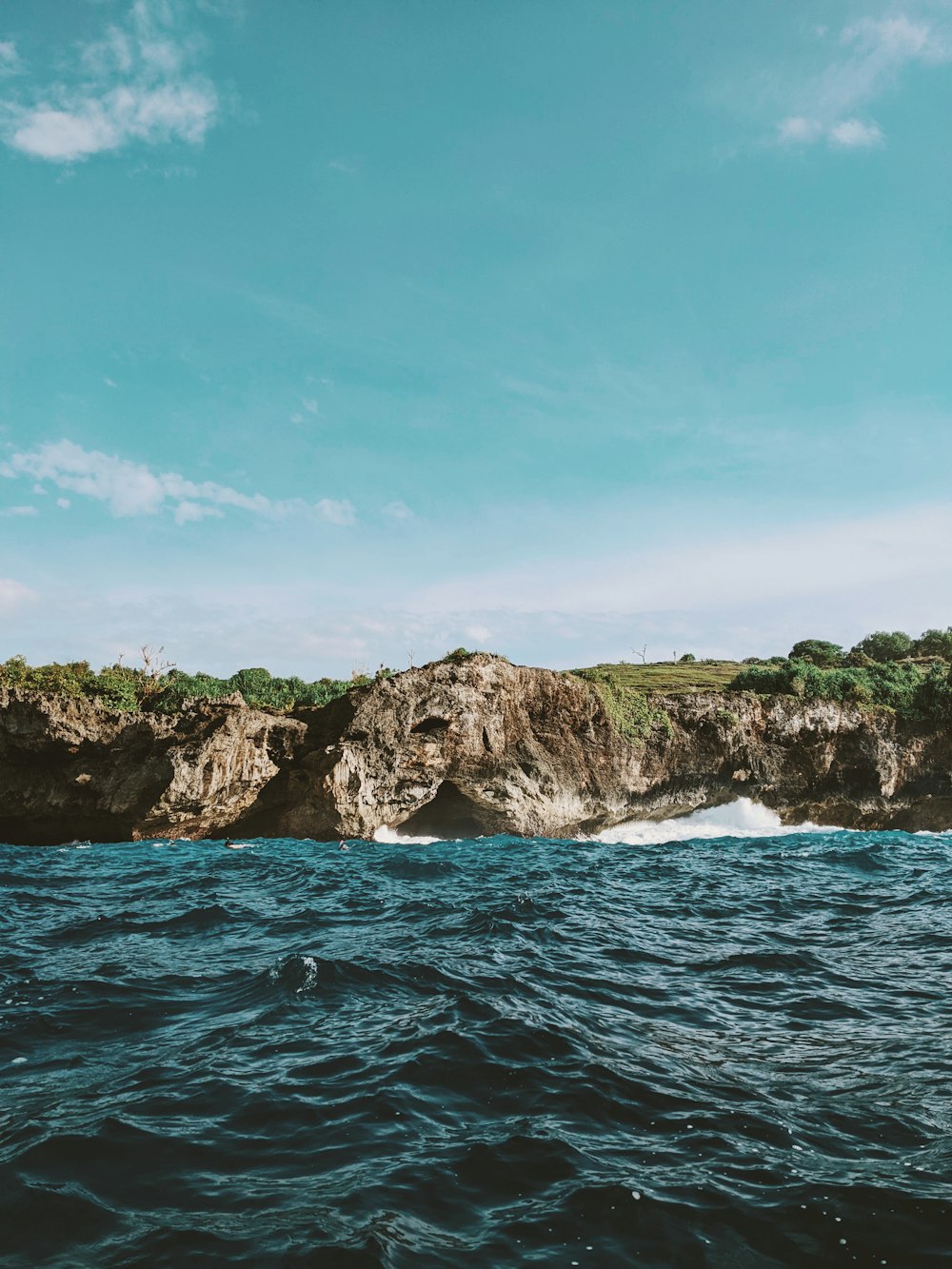 a large body of water with a rock formation in the background