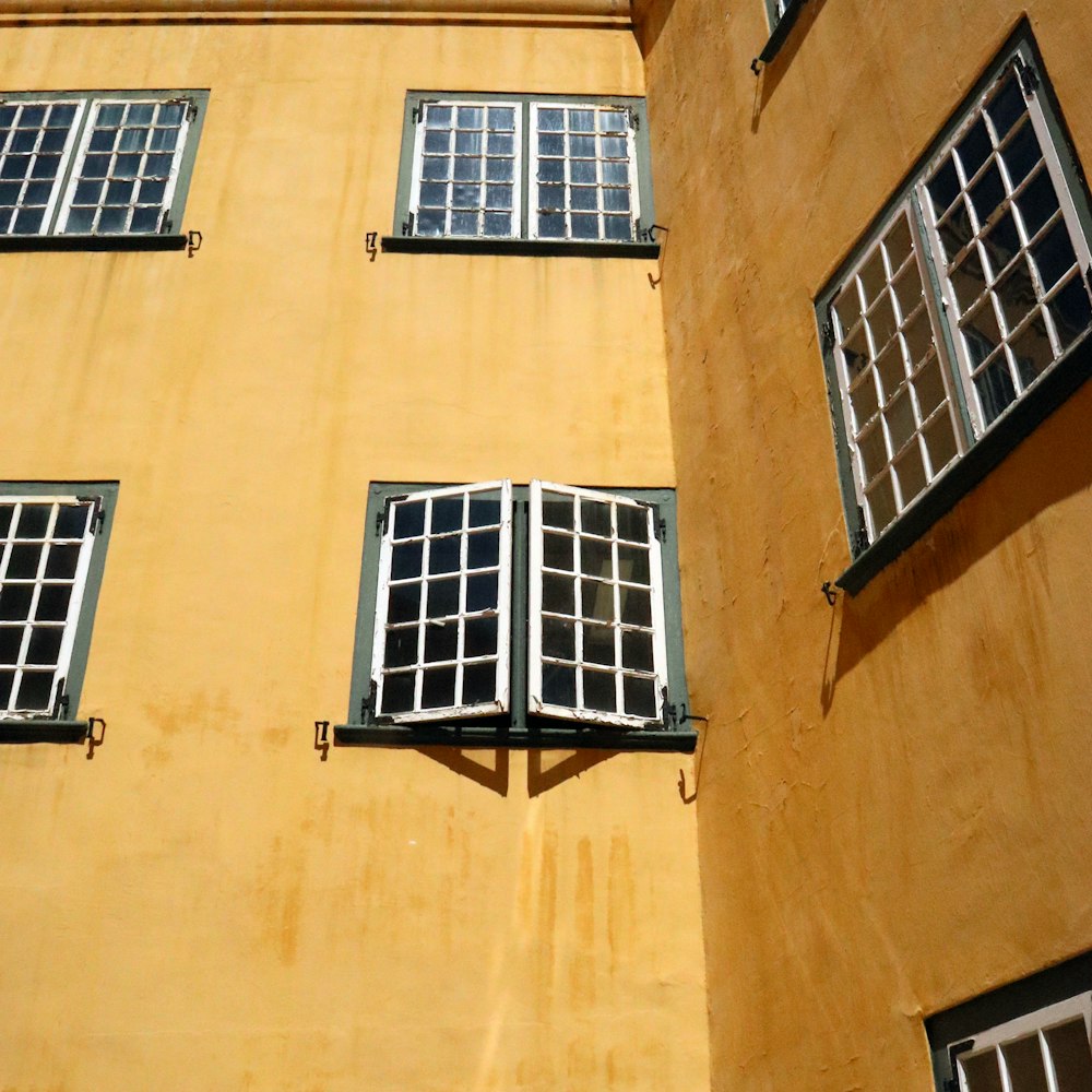 a yellow building with four windows and a clock