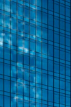 High-resolution shot of a glass facade reflecting the sky on an industrial site.