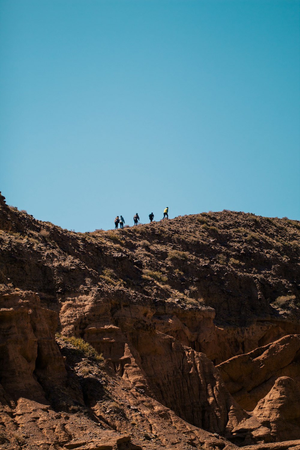 a group of people riding horses on top of a rocky hill